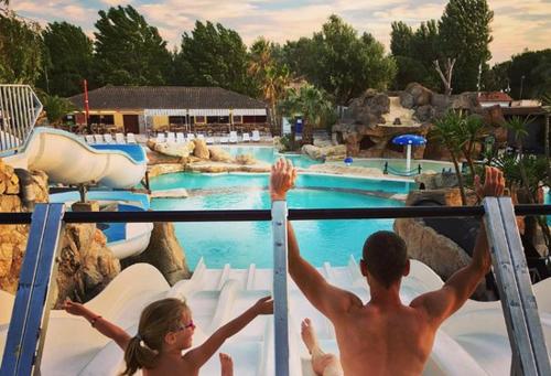 un homme et une femme sur un toboggan à la piscine dans l'établissement Ô Sables d’or, au Grau-dʼAgde