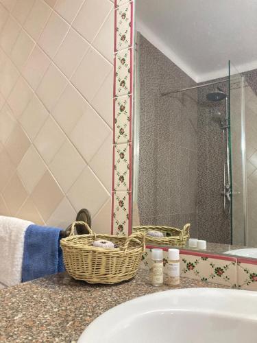 La salle de bains est pourvue d'un lavabo et d'un panier sur un comptoir. dans l'établissement Casa da Nazaré, à Portinho da Arrábida