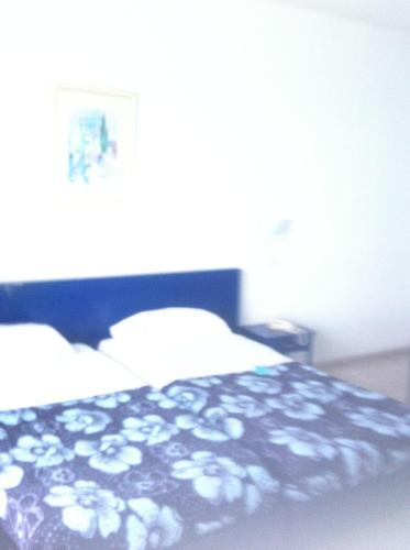 a bedroom with a bed with a black and white blanket at Residence Boujaafar in Sousse
