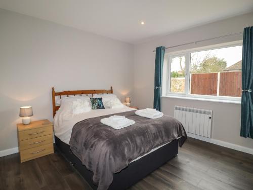 a bedroom with a large bed and a window at The Old Stables in Oasby