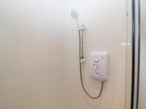 een douche met een douchekop in de badkamer bij The Old Stables in Oasby