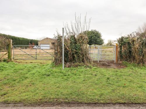 a gate in a field with a fence at The Old Stables in Oasby