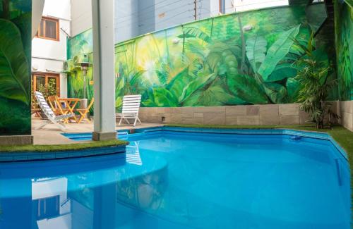 a swimming pool with a mural on the side of a building at Rainbow Hostel in Lima