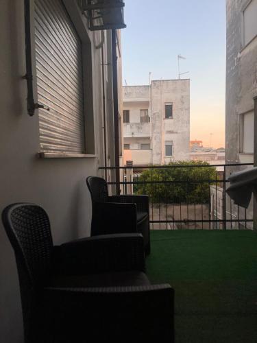 two chairs sitting on a balcony with a view of a building at A casa di Mary in Calimera