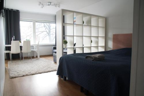 een slaapkamer met een blauw bed en een eetkamer bij 3-room apartment in Oulu center, parking in Oulu