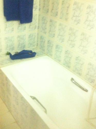 a bathroom with a toilet with a blue shoe on the counter at Residence Boujaafar in Sousse