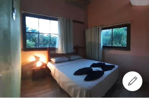 a bedroom with a bed with two towels on it at Pousadinha Ateliê da Maite in Paraty