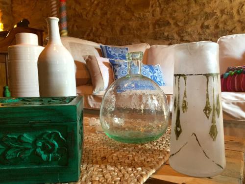 a table with a glass vase and other items on it at La Lolita ( Adults Only ) in Sant Martí Vell