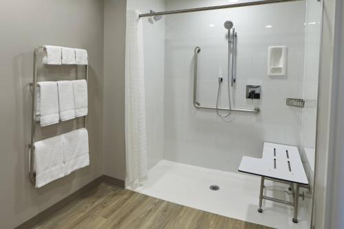 a white bathroom with a shower and a sink at TownePlace Suites by Marriott Hamilton in Hamilton