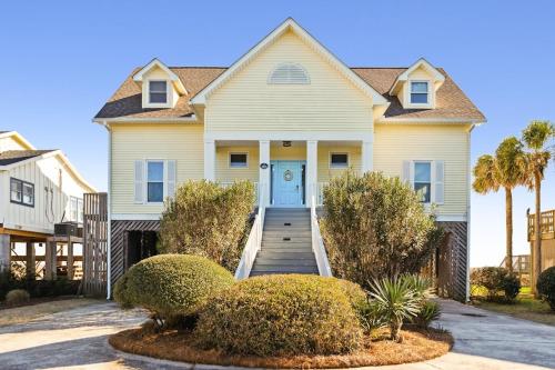 a house with a blue door and a porch at 1015 E Arctic Ave Dolphins Folly Oceanfront Home in Folly Beach