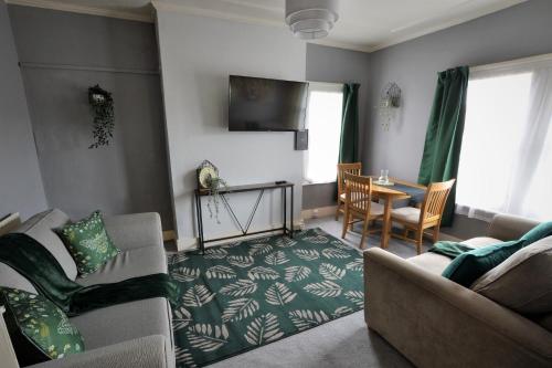 uma sala de estar com um sofá e uma mesa em Victoria Bay - Whole Apt - 2 Bed - WiFi - Beach - Harbour - Herne Bay em Herne Bay