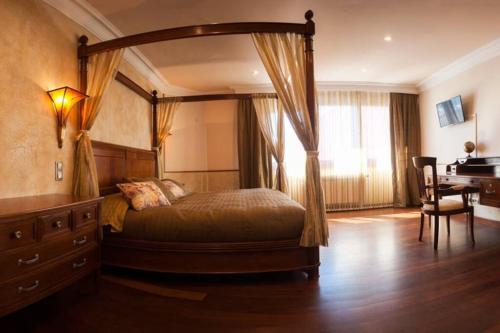 1 dormitorio con cama con dosel y escritorio en Casa Rural San Lorenzo, en Covaleda