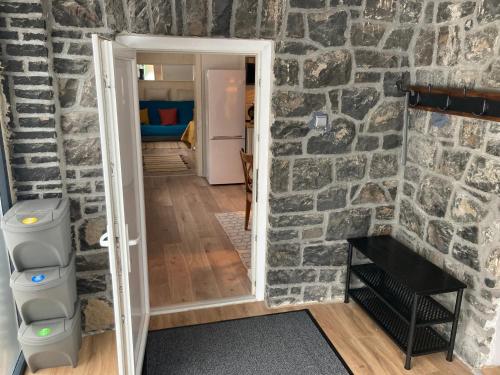 a room with a stone wall and a doorway at Lilakő Apartman in Mátraszentimre