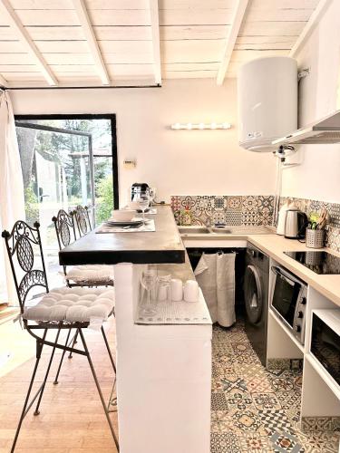 - une cuisine avec un comptoir et des chaises dans l'établissement CASA AZUL - jardin, calme, tennis, à Nîmes