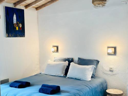 Schlafzimmer mit einem blauen Bett und weißen Kissen in der Unterkunft CASA AZUL - jardin, calme, tennis in Nîmes