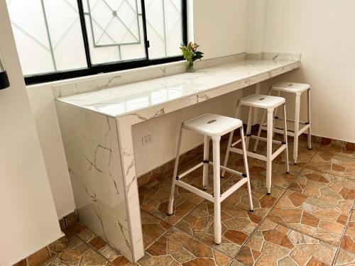 a kitchen with a counter and stools in a room at Tupac Huaraz in Huaraz