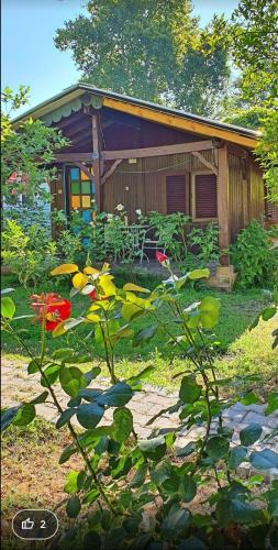 a house with a garden with flowers in front of it at Saklı Bahçe Pension in Cıralı