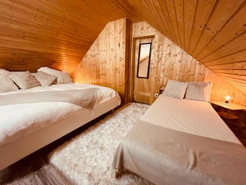 sypialnia z 2 łóżkami w drewnianym domku w obiekcie Brenner‘s Waldhaus w mieście Hergersweiler