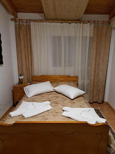 een bed met witte lakens en kussens erop bij KARMA's HOME BY DIMITROPOULOS Thermopilon street in Aigio