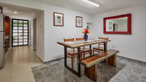 a dining room table with a bench and a mirror at Great location with all you need safe & beautiful in Mérida