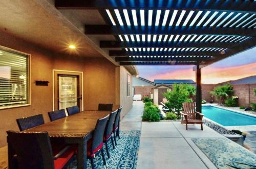 a patio with a table and chairs and a pool at Sand Hollow 3334 BBQ Grill, Private Splash Pad, Hot tub and Pool in Hurricane