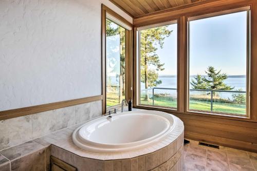 a large bath tub in a room with windows at Marrowstone Island Home 20 Mins to Port Townsend! in Nordland