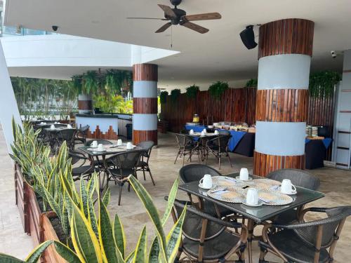 a restaurant with tables and chairs and a ceiling fan at Hermoso Apto Cartagena in Cartagena de Indias
