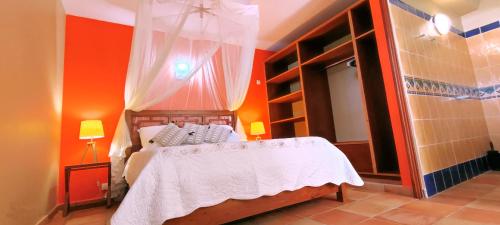1 dormitorio con 1 cama con pared de color naranja en T2 D'ALICE SAINTE ANNE CENTRE, en Sainte-Anne