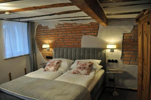 a bedroom with a bed and a brick wall at Hofgarten Rosa in Ilbesheim