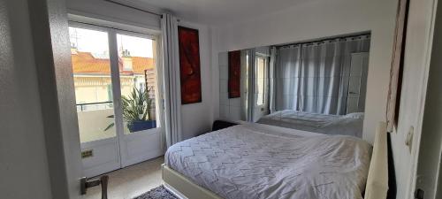 une petite chambre avec un lit et une fenêtre dans l'établissement CENTRE, 3P/TERRASSE , 300 m PLAGES., à Cannes