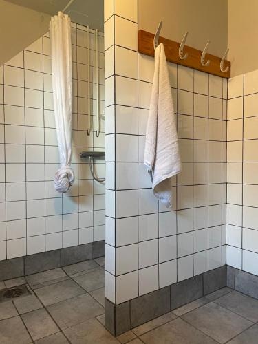 uma casa de banho com toalhas brancas penduradas numa parede em Casa Korallen em Varberg