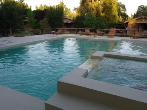 uma grande piscina com cadeiras num quintal em Villa Bonita Cabañas y Suites em San Rafael