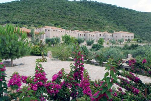 a large building with pink flowers in front of it at Smyros Resort in Poúlithra