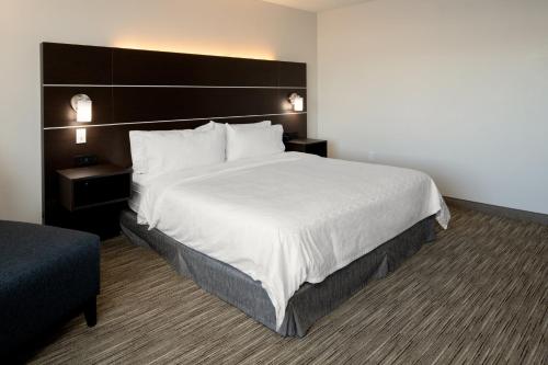 a hotel room with a large bed and a chair at Holiday Inn Express & Suites - Bullhead City by IHG in Bullhead City