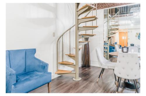 a living room with a blue couch and a spiral staircase at Altoona Grand Hotel in Altoona