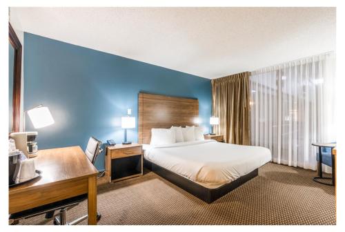 a hotel room with a bed and a desk at Altoona Grand Hotel in Altoona