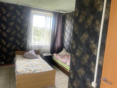 a small room with two beds and a window at Nakts zvaigzne in Rēzekne