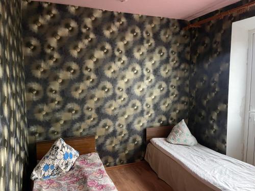 1 dormitorio con 2 camas y pared con papel pintado en Nakts zvaigzne en Rēzekne