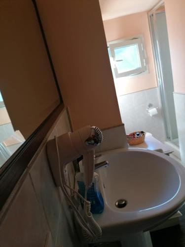 lavabo blanco en el baño con espejo en Il piccolo rifugio, en Soriano nel Cimino