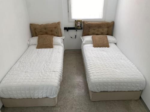 dos camas sentadas una al lado de la otra en una habitación en GREandCO PARKING PUBLICO GRATUITO, en Toledo