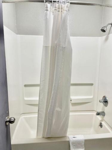 a bathroom with a shower curtain next to a sink at American Way Inn & Suites in Memphis