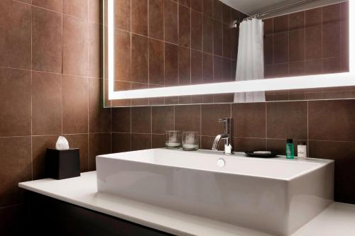 a bathroom with a white sink and a mirror at Sheraton Charlotte Hotel in Charlotte