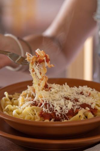 a person eating pasta on a plate with a fork at Tampu in Cachí