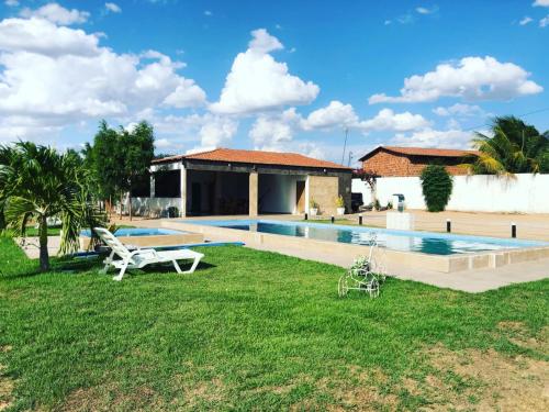 a yard with a swimming pool and a house at Casa privado com 3 quartos e piscina in Logradouro