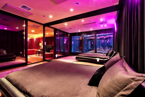 a bedroom with a bed in a room with purple lighting at Beyond: Historic Rock & Roll Studio in Sunfair Heights