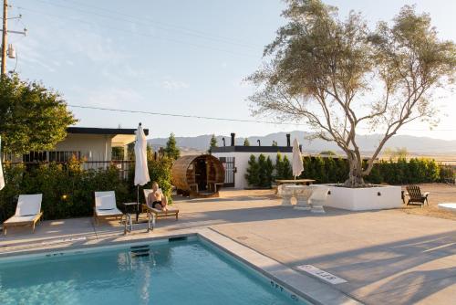 a person sitting in chairs next to a swimming pool at Cuyama Buckhorn in New Cuyama