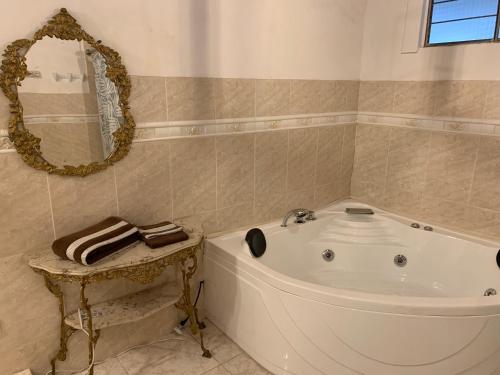 a white tub in a bathroom with a mirror at Casa Skema - Garden in Quito
