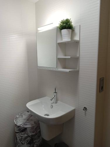 a white bathroom with a sink and a mirror at Apartamento Area Maior in Malpica