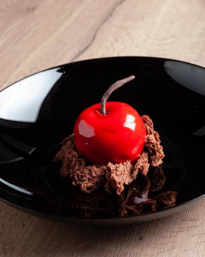 a chocolate dessert with a red cherry on top at Le Boeuf Couronné - Hôtel & Restaurant Chartres- Logis Hotels in Chartres