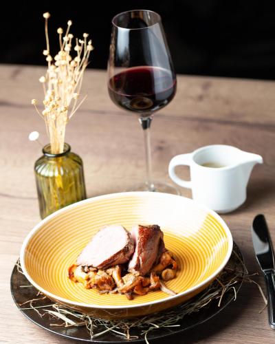 a plate of food on a table with a glass of wine at Le Boeuf Couronné - Hôtel & Restaurant Chartres- Logis Hotels in Chartres